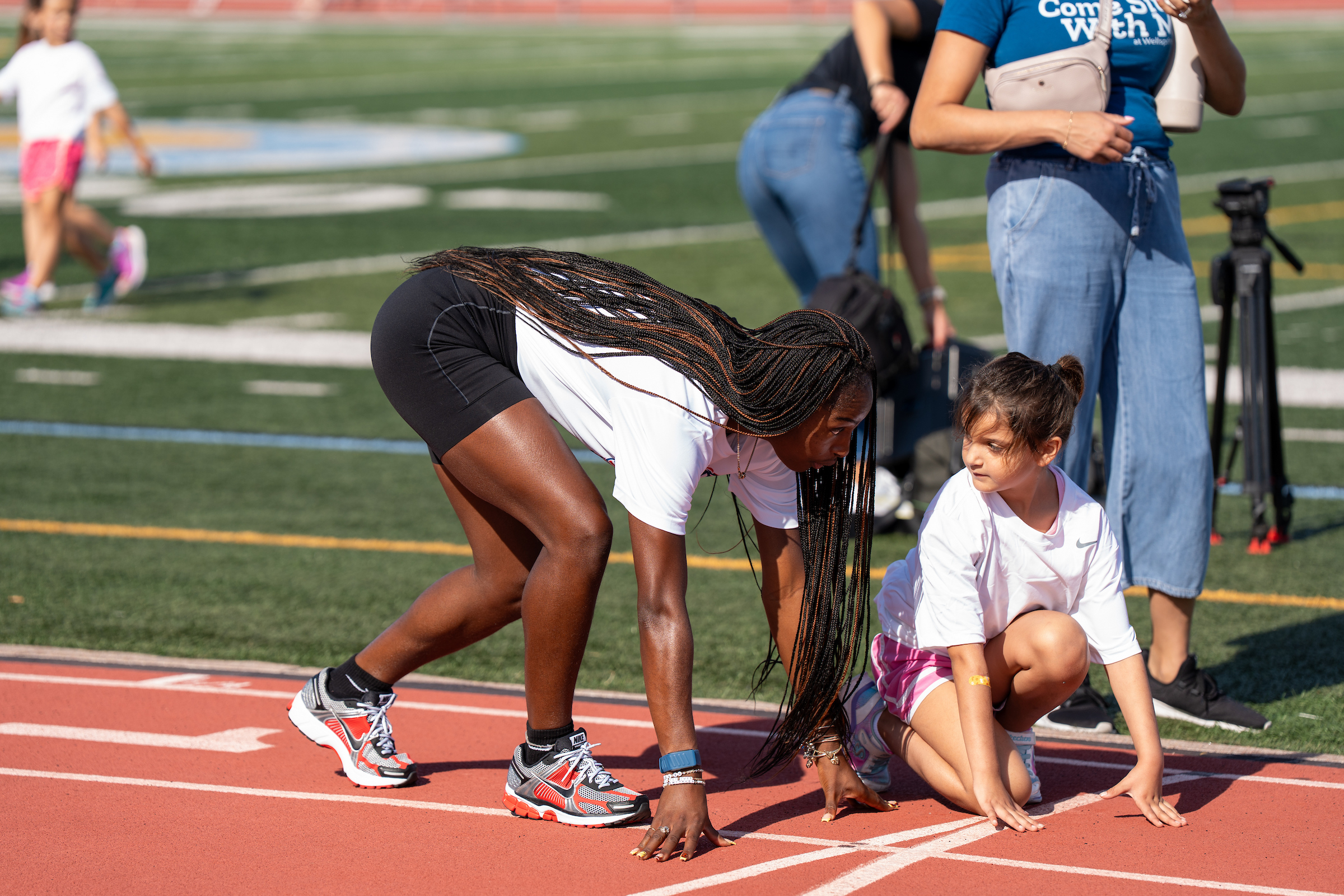 Twanisha TeeTee Terry demonstrates a track start with a young athlete at Doug Shaw Stadium in Myrtle Beach.